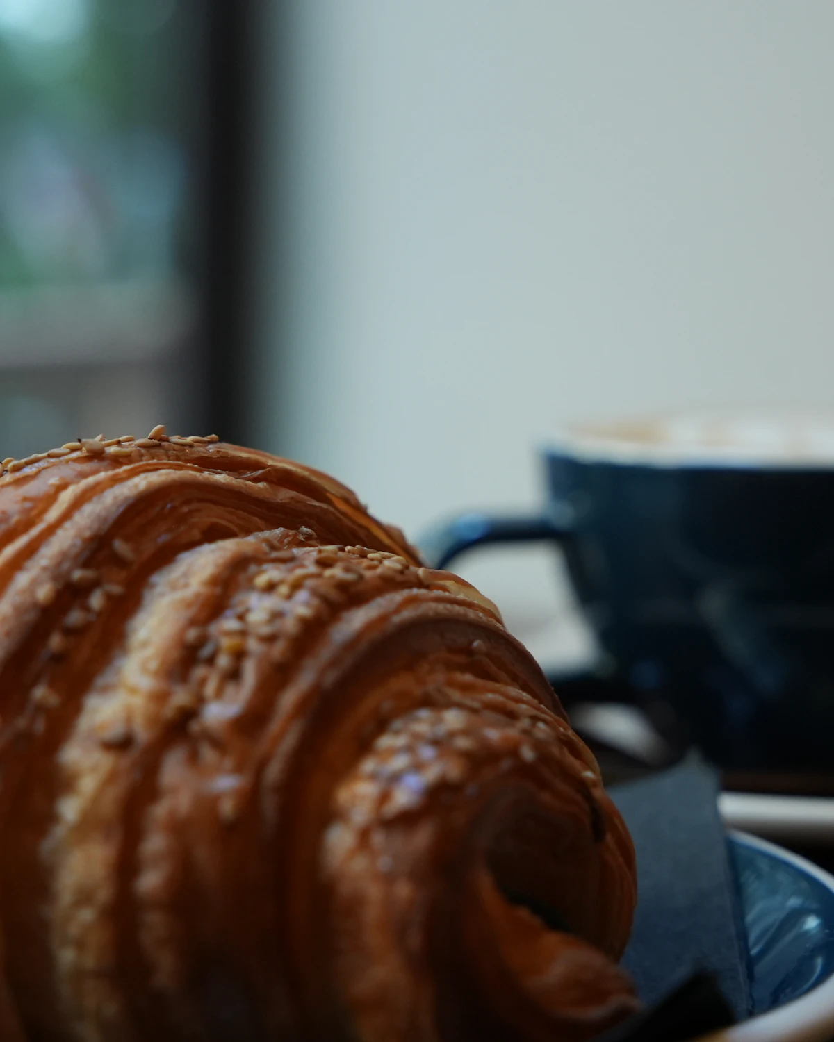 皿に盛り付けたクロワッサンとコーヒーカップ
